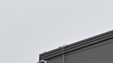 Imagen de un logotipo de la empresa Amazon, en un edificio de color negro.