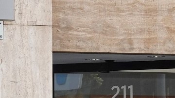 Imagen de un restaurante de la cadena Chipotle y afuera una persona con una chamarra azul que sostiene una bolsa.