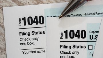 Imagen de dos formularios para declarar impuestos y de una pluma.