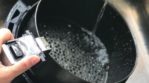 Imagen de una persona que lava una freidora de aire.