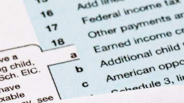 Imagen de formularios de impuestos y de cheques de reembolso, así como una calculadora.