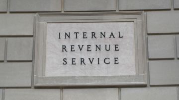 Imagen de una placa del IRS en un muro de color beige.