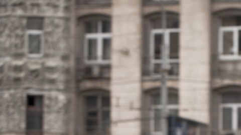 Imagen de una persona con una gabardina café que camina por la calle.