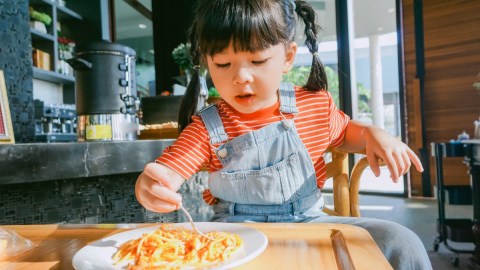 Imagen de una persona que sostiene un cubierto para comer pasta.
