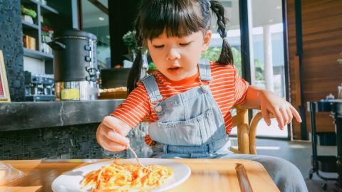 Imagen de una persona que sostiene un cubierto para comer pasta.