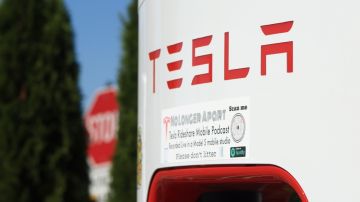 Imagen de un cargador de energía de la marca Tesla con las letras rojas de la marca.