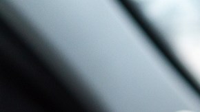 Imagen de una persona que conduce y que muestra un teléfono celular en cuya pantalla se ve el logotipo de la marca Uber.