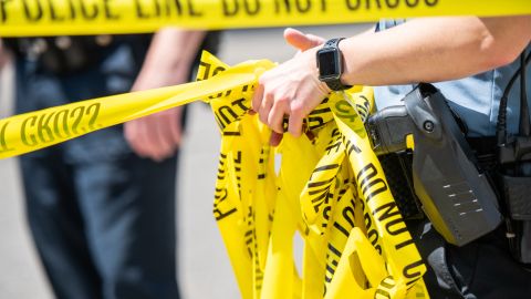 MINNEAPOLIS, MN - JUNE 16: A Minneapolis Police officer rolls up caution tape at a crime scene on June 16, 2020 in Minneapolis, Minnesota. The Minneapolis Police Department has been under close scrutiny following the death of George Floyd who died in police custody on May 25, 2020, after former officer Derek Chauvin kneeled on his neck for nearly nine minutes while detaining him. (Photo by Brandon Bell/Getty Images)