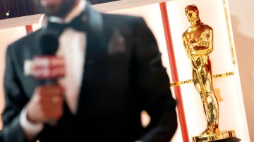 A member of the media speaks to camera near a decorative Oscar statue as final preparations are made for the 95th Academy Awards, in Hollywood, Los Angeles, California, on March 11, 2023. (Photo by Stefani Reynolds / AFP) (Photo by STEFANI REYNOLDS/AFP via Getty Images)