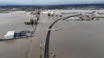 This aerial photograph shows floodwaters submerging the road to enter Pajaro, California, on March 11, 2023. - Residents were forced to evacuate in the middle of the night after an atmospheric river surge broke the the Pajaro Levee and sent flood waters flowing into the community. (Photo by JOSH EDELSON / AFP) (Photo by JOSH EDELSON/AFP via Getty Images)