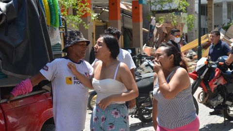 Vecinos lloran tras el terremoto que destruyó edificios en la ciudad de Machala, en Ecuador.