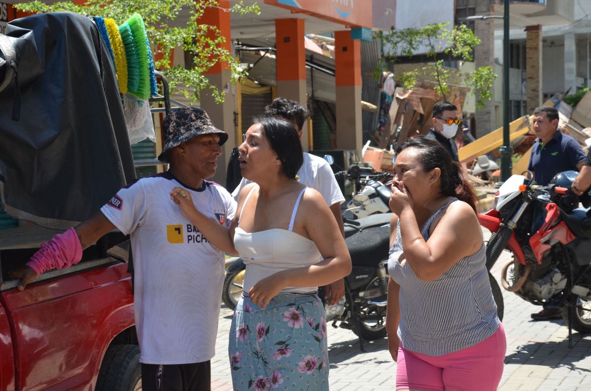 Vecinos lloran tras el terremoto que destruyó edificios en la ciudad de Machala, en Ecuador.