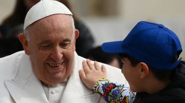 Un niño le da una palmadita en el hombro al Papa Francisco el 29 de marzo de 2023 en El Vaticano.