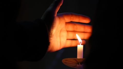 LOS ANGELES, CALIFORNIA - DECEMBER 01: A person holds a candle during a World AIDS Day commemoration event at The Wall Las Memorias AIDS Monument on December 1, 2022 in Los Angeles, California. The Biden administration today released a five-year strategy to end the HIV/AIDS epidemic worldwide by the year 2030. (Photo by Mario Tama/Getty Images)