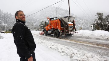 MOUNT BALDY, CALIFORNIA - FEBRUARY 24: A person watches a snowplow operate in the San Gabriel Mountains in San Bernardino County near the border of Los Angeles County on February 24, 2023 in Mount Baldy, California. A major storm, carrying a rare blizzard warning for parts of Southern California, has begun to deliver heavy snowfall to the mountains with some snowfall expected to reach lower elevations in Los Angeles County. (Photo by Mario Tama/Getty Images)