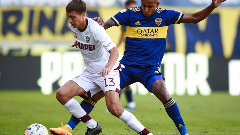 Julián Aude con los colores del Lanús disputa el balón con Sebastián Villa del Boca Juniors.
