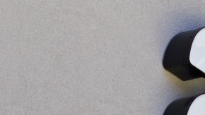 Imagen de un logotipo de Amazon colocado sobre el muro de un edificio de color gris.