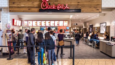 Imagen de un restaurante de la cadena Chick-Fil-A, en la que se ve a un grupo de personas haciendo fila para ordenar.