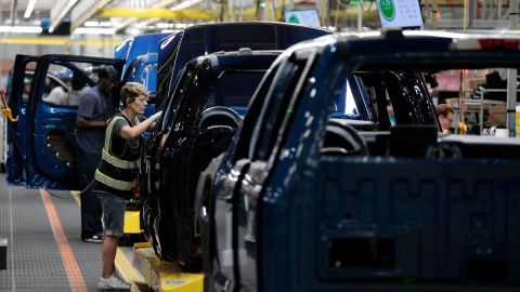Imagen de una persona que trabaja en una línea de producción de camionetas.