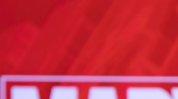 Imagen de un fondo de color rojo con las letras de la marca Marvel y de un teléfono celular en cuya pantalla se ve el logotipo de la empresa Disney+.