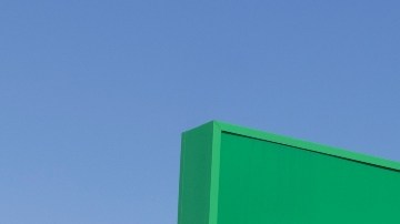 Imagen de un letrero de color verde con letras blancas de Dollar Tree y en el fondo el acceso a una tienda.
