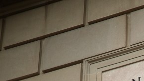 Imagen de un edificio del IRS, con una placa que muestra la leyenda Internal Revenue Service, en medio de un semáforo en color verde.
