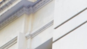 Imagen del logotipo de la tienda departamental, Macy's, en color blanco, con una estrella de color rojo. Colocado sobre una marquesina de color gris oscuro.