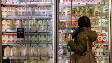 Imagen de una persona que abre un refrigerador para tomar productos.