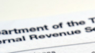 Imagen de un cheque de reembolso de impuestos y de un sobre del IRS.