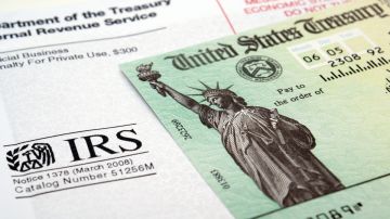 Imagen de un cheque de reembolso de impuestos y de un sobre del IRS.