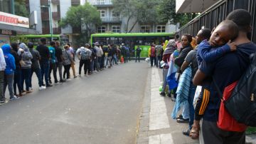 Inmigrantes en Ciudad México esperan para ser trasladados a un albergue en la alcaldía de Tláhuac.