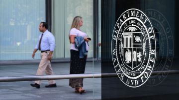 Pedestrians walk past the Los Angeles Department of Water and Power headquarters in Los Angeles, California on July 22, 2019. - FBI agents served search warrants to today as part of a probe into the city's handling of a litigation and a settlement over the botched rollout of a DWP billing system. (Photo by Frederic J. BROWN / AFP) (Photo credit should read FREDERIC J. BROWN/AFP via Getty Images)