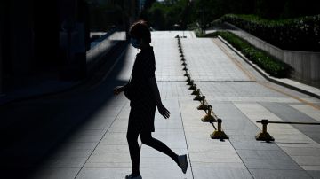A woman walks along a street in Beijing on July 14, 2022. (Photo by WANG Zhao / AFP) (Photo by WANG ZHAO/AFP via Getty Images)