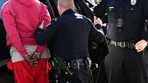 A Los Angeles Police Department (LAPD) officer wears an Axon body camera (R) as a Black driver is handcuffed and placed into a patrol car during a traffic stop by officers on Crenshaw Blvd in Los Angeles, California on January 31, 2023. (Photo by Patrick T. Fallon / AFP) (Photo by PATRICK T. FALLON/AFP via Getty Images)