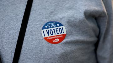 Una persona muestra un botón de voto de las elecciones primarias de 2022 en Florida.