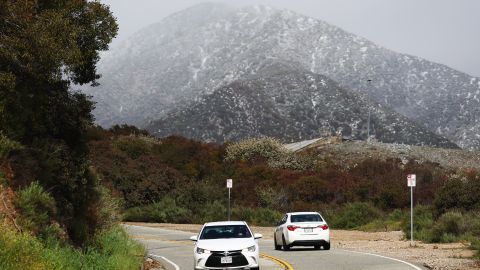 CLAREMONT, CALIFORNIA - FEBRUARY 23: Vehicles drive in the foothills of the San Gabriel Mountains with a dusting of snow in Los Angeles County on February 23, 2023 near Claremont, California. A major storm, carrying a rare blizzard warning for parts of Southern California, is expected to deliver heavy snowfall to the mountains with some snowfall expected to reach lower elevations in L.A. County. (Photo by Mario Tama/Getty Images)