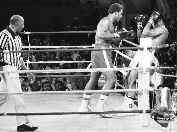 Le champion du monde de boxe des poids lourds américain George Foreman (C) pousse son compatriote Mohamed Ali (Cassius Clay) (D) dans les cordes sous le regard de l'arbitre (G) à Kinshasa le 30 octobre 1974 lors du combat à l'issu duquel Mohamed Ali, reprenant l'offensive, lui ravira son titre. A picture taken September 30 1974 in Kinshasa of the fight opposing former world heavyweight boxing champion the American Muhammad Ali (R) and his compatriot and titleholder George Foreman (C). Ali won and got back his title. (Photo credit should read -/AFP via Getty Images)