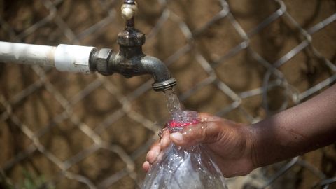 A child fills a bottle with water from a public tap in the 8th Commune in Medellin, Antioquia department, Colombia on March 22, 2013. The commune residents have to walk to collect water due to the lack of running water in the neighborhood. The World Water Day calls for international attention on the preservation of the world's drinking water resources. AFP PHOTO/ Raul ARBOLEDA (Photo by RAUL ARBOLEDA / AFP) (Photo by RAUL ARBOLEDA/AFP via Getty Images)