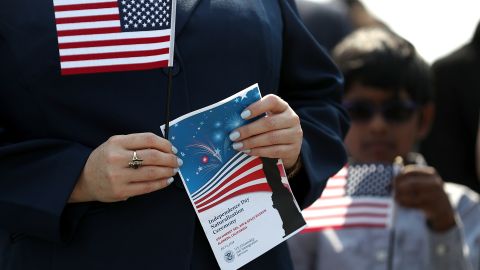 ALAMEDA, CA - JULY 03: An immigrant holds an American flag before being sworn in as an American citizen during a naturalization ceremony on the flight deck of the USS Hornet on July 3, 2018 in Alameda, California. 76 immigrants from 31 countries were sworn in as American citizens during a ceremony aboard the historic USS Hornet aircraft carrier. (Photo by Justin Sullivan/Getty Images)