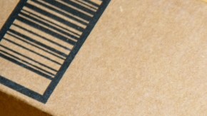 Imagen de una caja de cartón de Amazon, dejada en un piso de madera.