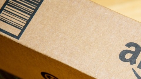 Imagen de una caja de cartón de Amazon, dejada en un piso de madera.