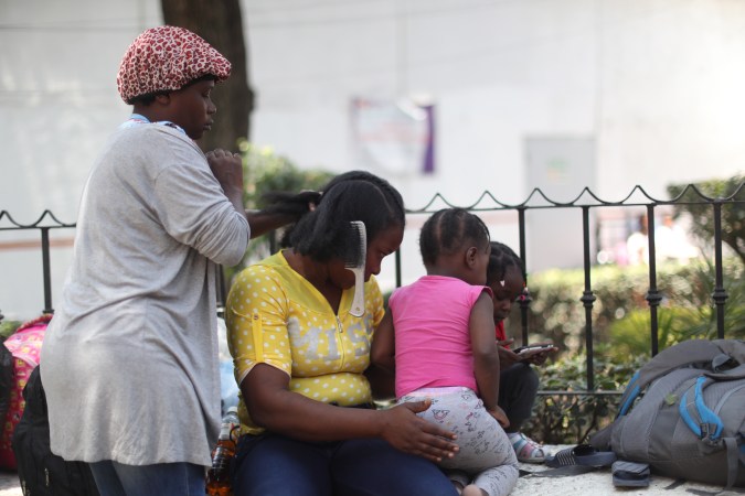 Migrantes haitianos esperan frente a las oficinas de la Comisión Mexicana de Ayuda a Refugiados (COMAR), en Ciudad de México.