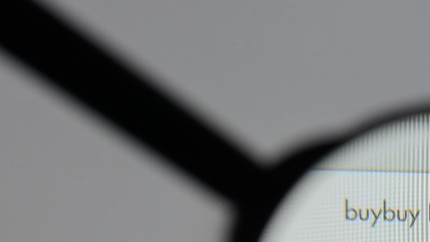 Imagen de una lupa que amplifica el logotipo de la empresa Bed Bath & Beyond, visto en la pantalla de una computadora.