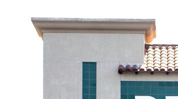 Imagen de una tienda de la marca Bed Bath & Beyond, con una marquesina de color verde y letras blancas, en medio de un estacionamiento.