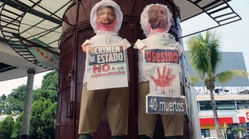 Migrantes en la frontera sur de México caricaturizan en protesta a López Obrador y lo llaman asesino