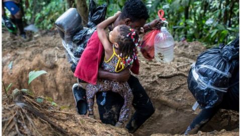 Los adultos cargan a los niños en los tramos más difíciles del cruce por el Darién.