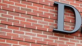 Imagen de una tienda de la marca David’s Bridal, en la que se ve una tienda con aparadores de cristal y una marquesina con letras de color negro.