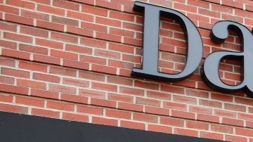 Imagen de una tienda de la marca David’s Bridal, en la que se ve una tienda con aparadores de cristal y una marquesina con letras de color negro.