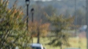 Imagen de una persona que camina con unos documentos en la mano a través de una feria de empleo.