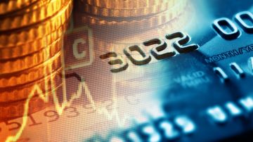 Imagen de monedas apiladas y una tarjeta de crédito azul, junto con indicadores financieros.